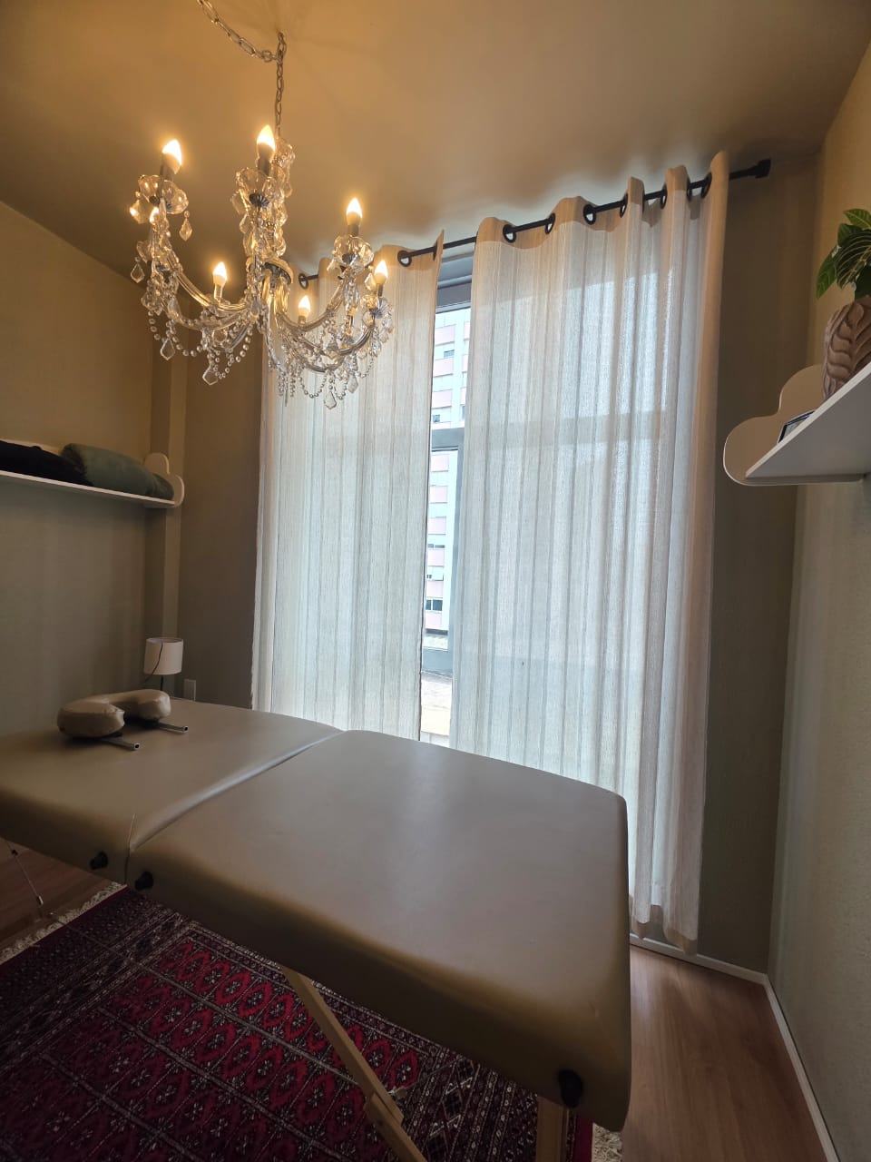 Sala 02 — sala de terapia com maca, lustre de cristal e cortina clara
